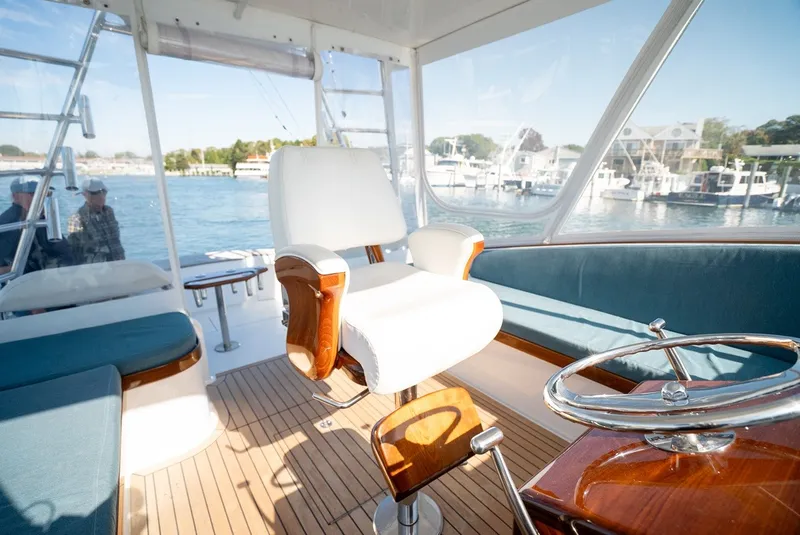 Slide: The Image of Interior of a 2017 Lightning Custom Yachts 37 Express Sportfish with a white captain's chair and wood accents. - 31