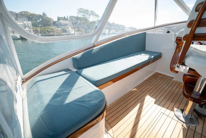 Slide: The Image of The image shows the cockpit of a 2017 Lightning Custom Yachts 37 Express Sportfish with blue cushions and wooden flooring. - 34