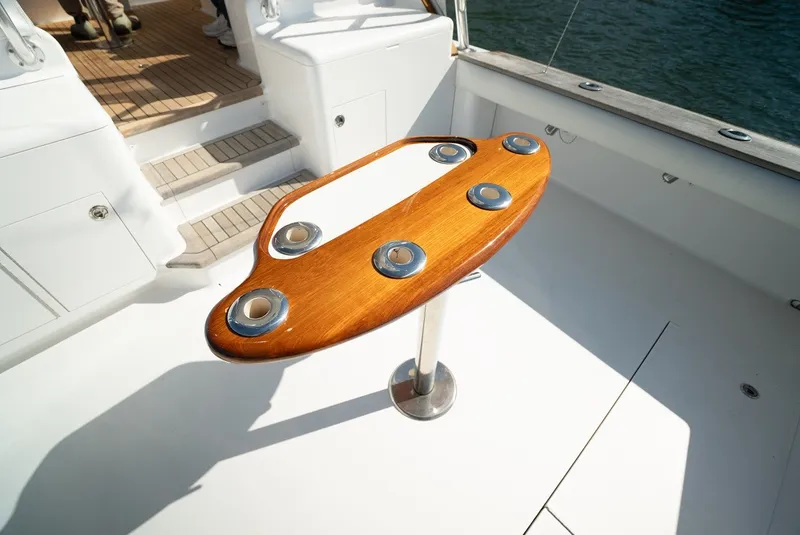 Slide: The Image of Wooden fishing station on a sportfishing boat with stainless steel holders, surrounded by white deck. - 17