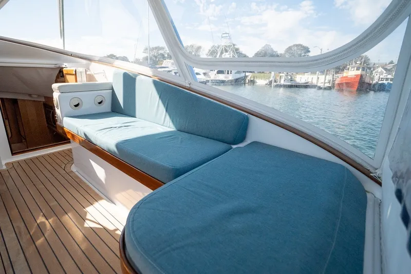 Slide: The Image of The 2017 Lightning Custom Yachts 37 Express Sportfish features a cozy seating area with blue cushions and wooden flooring. - 33