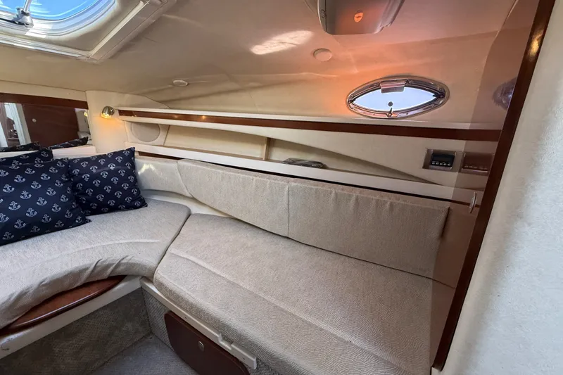 Slide: The Image of Interior of 2008 Sea Ray Sundancer 260 with cozy seating and nautical-themed pillows. - 29