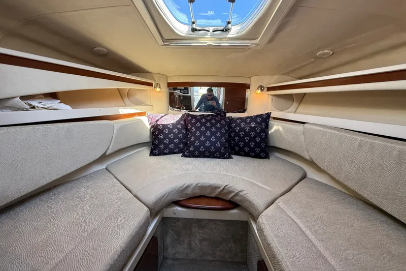 Slide: The Image of Interior of 2008 Sea Ray Sundancer 260 with cozy seating and nautical-themed pillows. - 28