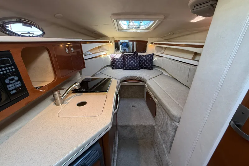 Slide: The Image of Interior of 2008 Sea Ray Sundancer 260, featuring cozy seating and compact kitchenette. - 20