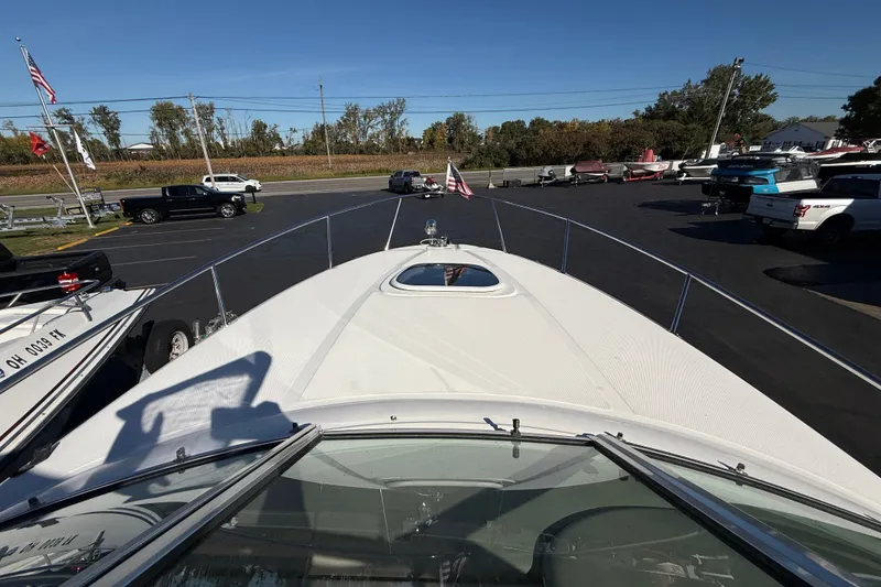 Slide: The Image of 2008 Sea Ray Sundancer 260 boat on display in a parking lot with clear skies. - 17