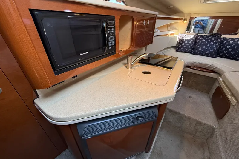 Slide: The Image of 2008 Sea Ray Sundancer 260 cabin interior with kitchenette and seating area. - 27