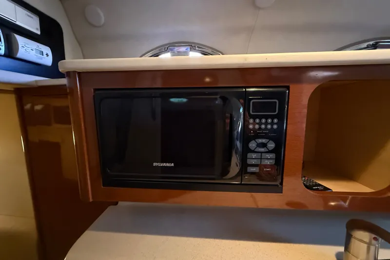 Slide: The Image of Microwave in 2008 Sea Ray Sundancer 260 cabin, featuring wood cabinetry and modern controls. - 33