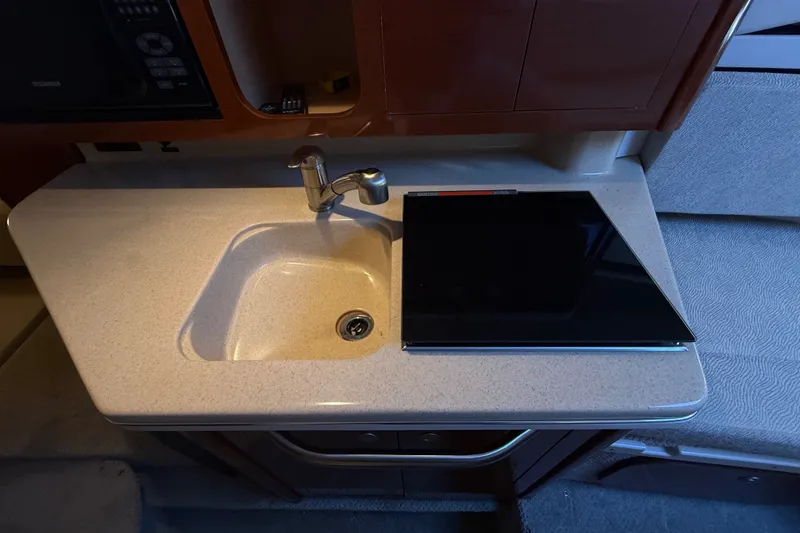 Slide: The Image of Compact kitchen sink and stove in 2008 Sea Ray Sundancer 260 boat interior. - 32