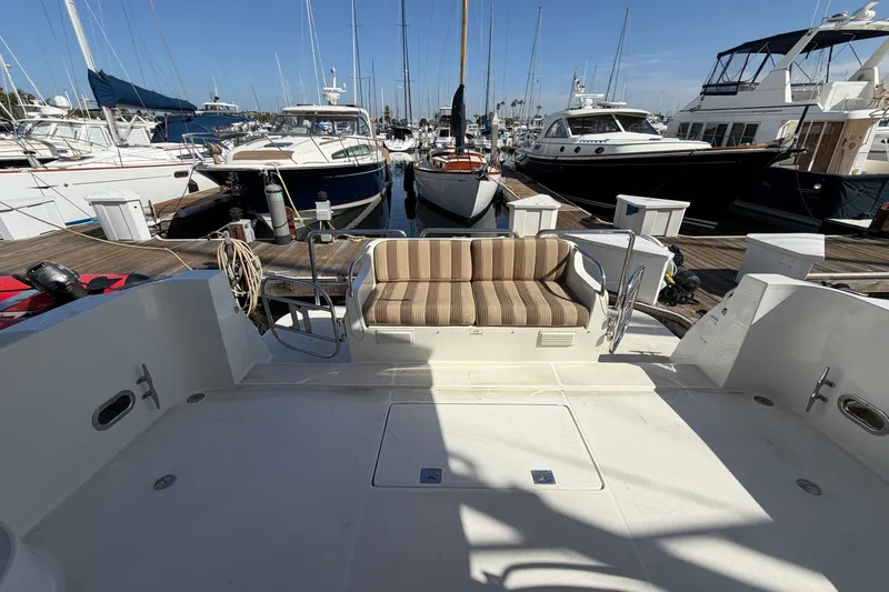 Slide: The Image of 2009 Navigator 5800 Pilothouse MY yacht docked at marina with striped seating. - 6