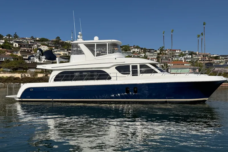 Slide: The Image of 2009 Navigator 5800 Pilothouse MY yacht on calm water, coastal homes in background. - 4