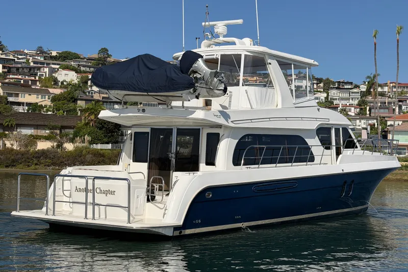 Slide: The Image of 2009 Navigator 5800 Pilothouse MY yacht docked near coastal homes. - 3