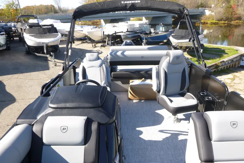 Slide: The Image of 2027 Premier 250 SUNSATION RLO - CL pontoon boat interior with seating and helm, docked outdoors. - 16