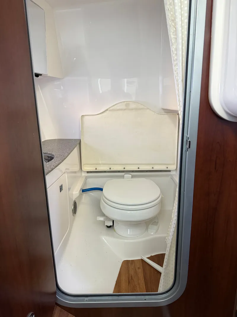 Slide: The Image of The image shows a boat bathroom with a white toilet, sink, and shower curtain. - 4