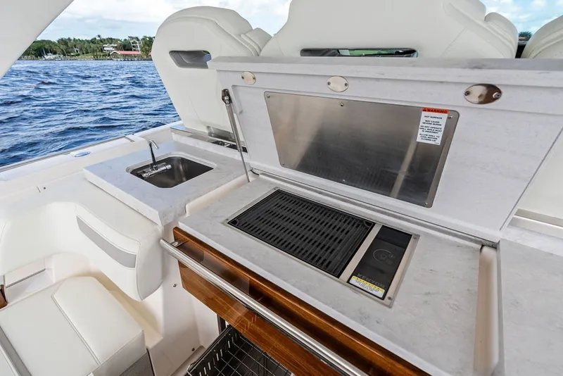 Slide: The Image of 2024 Tiara Yachts 38 LS yacht with outdoor kitchen and sink by the water. - 40