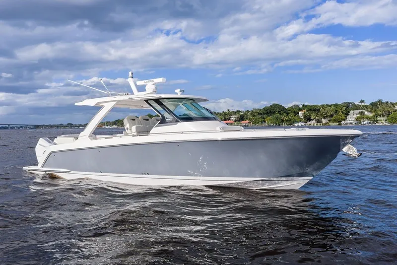 Slide: The Image of 2024 Tiara Yachts 38 LS cruising on a sunny day with scenic shoreline backdrop. - 20