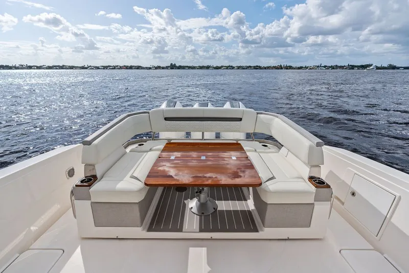 Slide: The Image of 2024 Tiara Yachts 38 LS luxury seating area with ocean view and wooden table. - 32