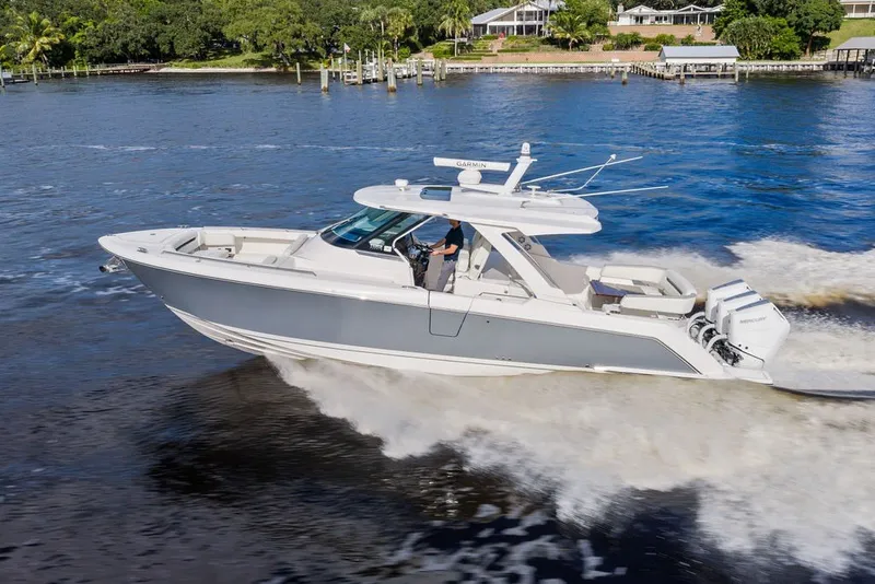 Slide: The Image of 2024 Tiara Yachts 38 LS cruising on a scenic waterway, showcasing sleek design and powerful engines. - 9
