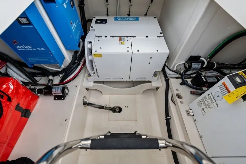 Slide: The Image of Engine room of 2024 Tiara Yachts 38 LS, featuring battery chargers and electrical components. - 58
