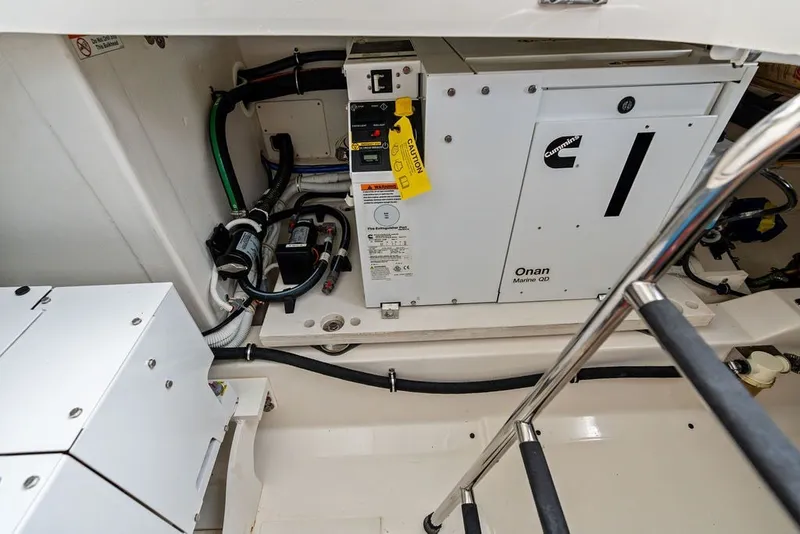Slide: The Image of Engine compartment of 2024 Tiara Yachts 38 LS, featuring Cummins Onan Marine generator. - 59