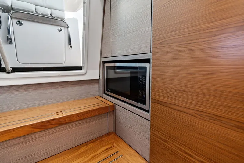 Slide: The Image of 2024 Tiara Yachts 38 LS interior with microwave and wooden cabinetry. - 56