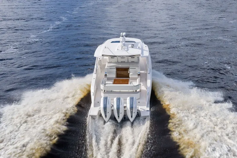 Slide: The Image of 2024 Tiara Yachts 38 LS cruising on open water, rear view with powerful engines. - 12
