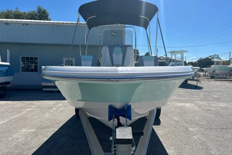 The Image of 2024 Robalo 206 Cayman boat with canopy, parked outdoors under clear blue sky. - 0
