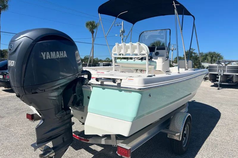 Slide: The Image of 2024 Robalo 206 Cayman boat with Yamaha engine, parked on trailer under clear blue sky. - 4