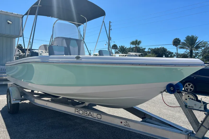 Slide: The Image of 2024 Robalo 206 Cayman boat on trailer, featuring sleek design and mint green hull. - 5