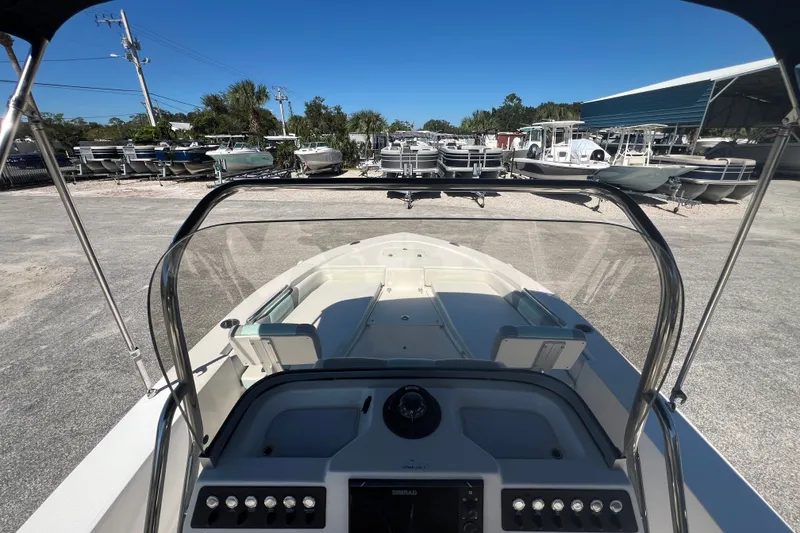 Slide: The Image of 2024 Robalo 206 Cayman boat interior view at a marina under clear blue sky. - 14