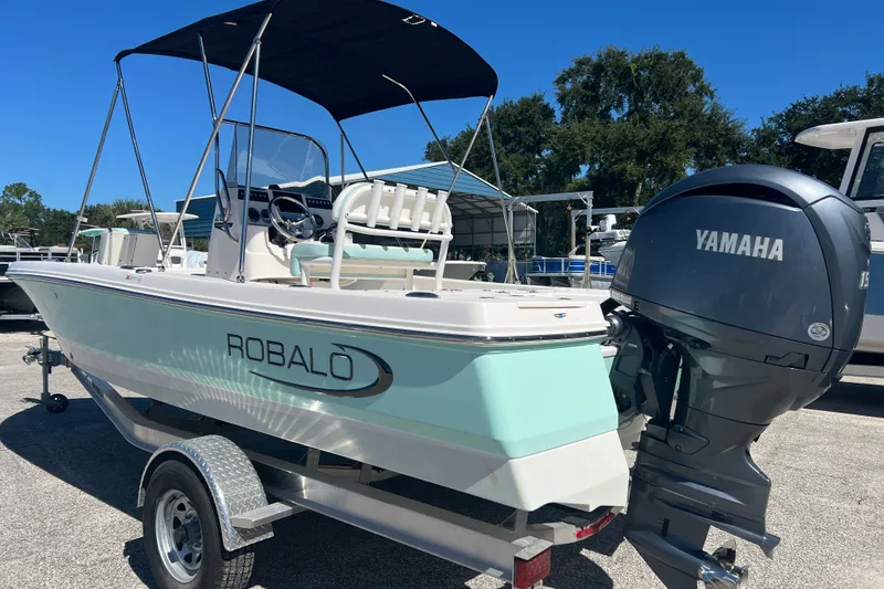 Slide: The Image of 2024 Robalo 206 Cayman boat with Yamaha engine on trailer, outdoor setting. - 2