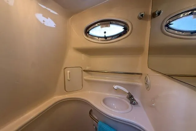 Slide: The Image of 2000 Sea Ray 340 Sundancer bathroom with sink, mirror, and porthole window. - 46