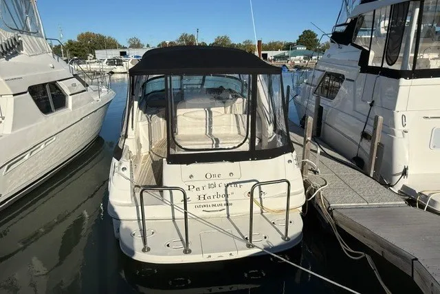 Slide: The Image of 2000 Sea Ray 340 Sundancer docked at a marina, rear view with canopy. - 2