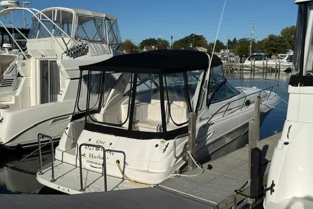 Slide: The Image of 2000 Sea Ray 340 Sundancer docked at marina with black canopy and white hull. - 3