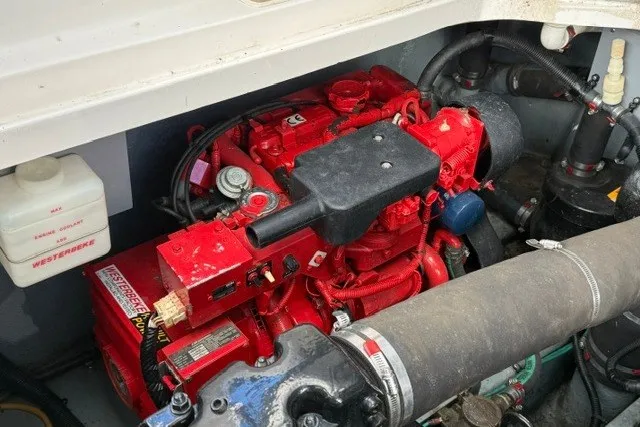 Slide: The Image of Engine compartment of a 2000 Sea Ray 340 Sundancer boat with red engine components. - 57
