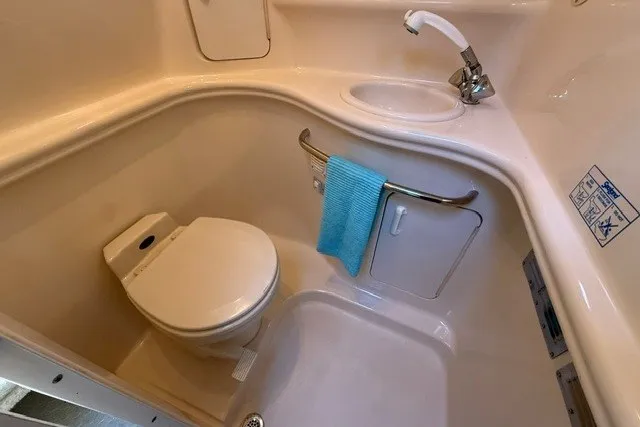 Slide: The Image of 2000 Sea Ray 340 Sundancer bathroom with toilet, sink, and blue towel. - 47