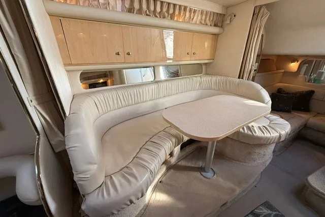 Slide: The Image of Interior of 2000 Sea Ray 340 Sundancer with plush seating and dining table. - 43