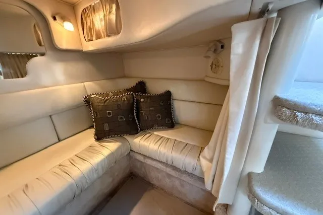 Slide: The Image of Cozy interior of 2000 Sea Ray 340 Sundancer with cushioned seating and decorative pillows. - 52