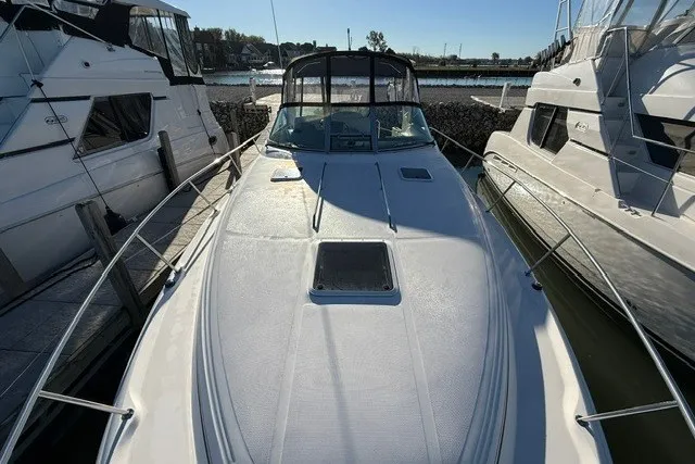 Slide: The Image of 2000 Sea Ray 340 Sundancer docked between boats, showcasing sleek design and spacious deck. - 5