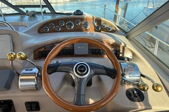 Slide: The Image of Helm of 2000 Sea Ray 340 Sundancer with wooden steering wheel and control panel. - 23
