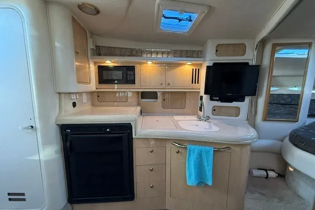 Slide: The Image of Interior of 2000 Sea Ray 340 Sundancer yacht with kitchenette and modern amenities. - 31