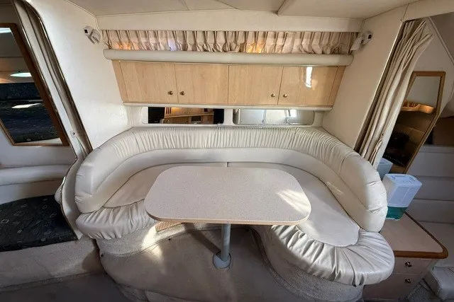 Slide: The Image of Interior of 2000 Sea Ray 340 Sundancer with curved seating and table. - 29
