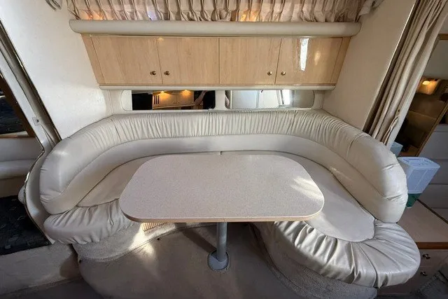 Slide: The Image of Interior of 2000 Sea Ray 340 Sundancer with curved seating and table. - 44