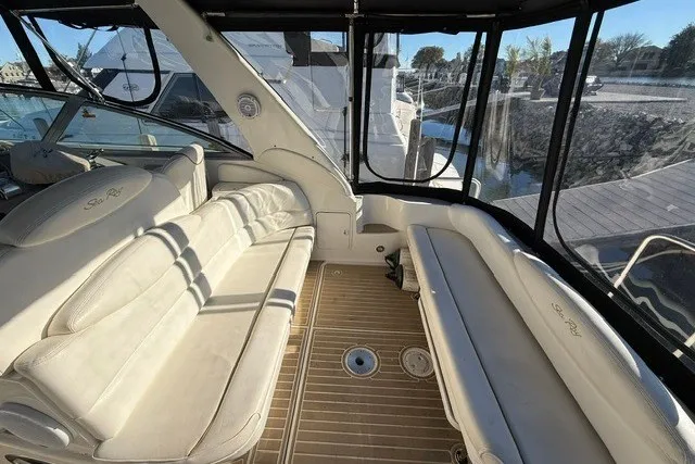 Slide: The Image of Interior view of 2000 Sea Ray 340 Sundancer yacht with beige seating and wooden flooring. - 8