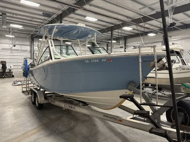 The Image of A 2020 Cobia 240 Dual Console sits on a trailer in a storage facility. - 0