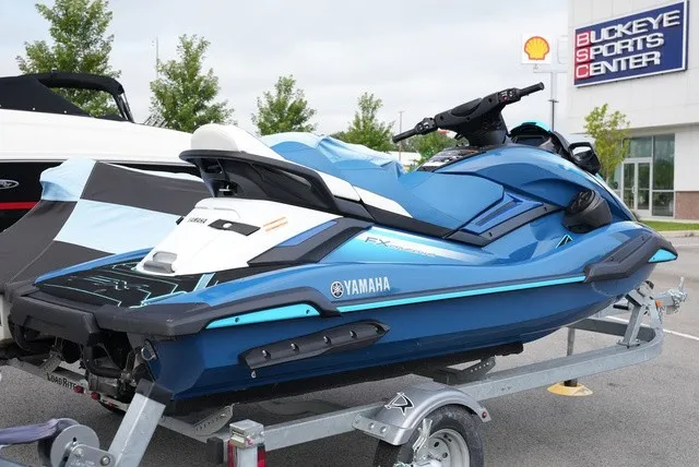 Slide: The Image of 2024 Yamaha WaveRunner FX Cruiser HO in blue on a trailer outside a sports center. - 4