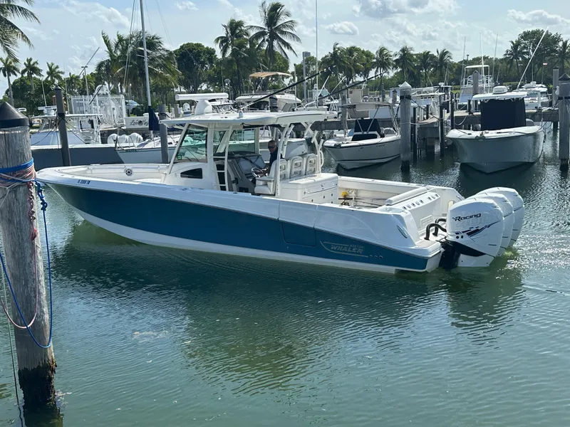 Slide: The Image of Ein Boston Whaler 380 Outrage von 2017 liegt im Wasser eines Yachthafens, umgeben von anderen Booten. - 10