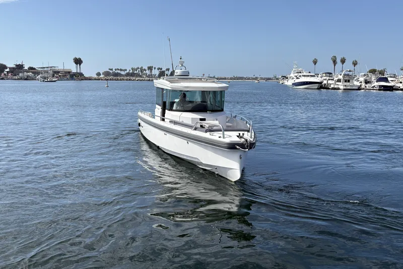 Slide: The Image of 2021 Axopar 28 Cabin boat cruising in a scenic marina setting. - 4