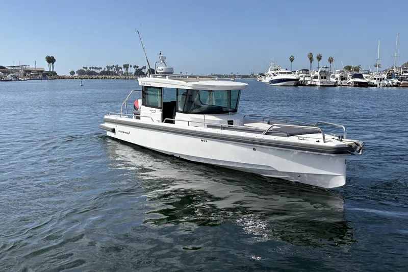 Slide: The Image of 2021 Axopar 28 Cabin boat cruising in a marina with palm trees in the background. - 3