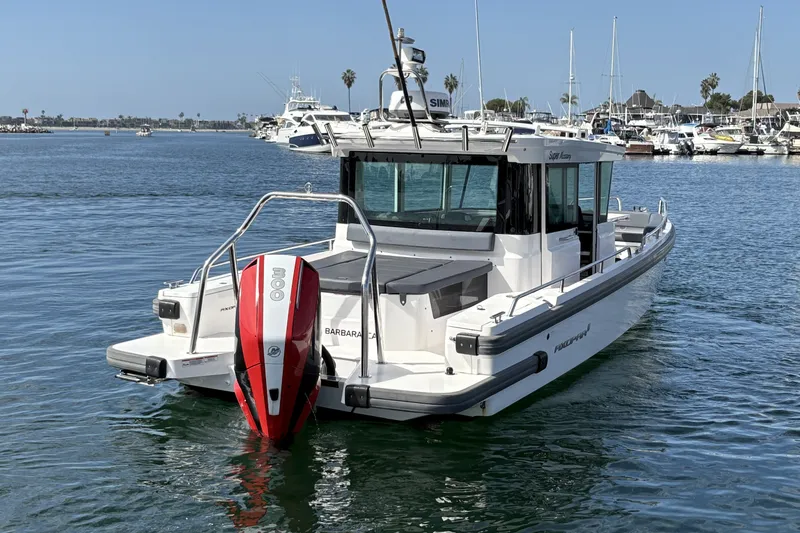 Slide: The Image of 2021 Axopar 28 Cabin boat with red outboard motor on calm water. - 6