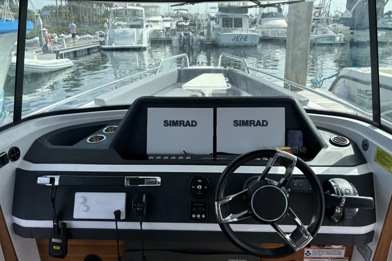 Slide: The Image of 2021 Axopar 28 Cabin boat dashboard with Simrad navigation system at marina. - 8