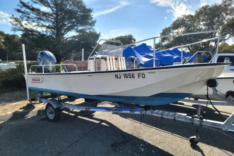 Slide: The Image of 1986 Boston Whaler 17 Montauk boat on trailer, parked outdoors. - 17